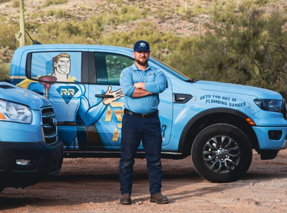 Plumbers from Rooter Ranger Standing Near Service Trucks